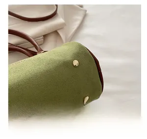 Detail shot of golden protective base studs on a vintage frosted leather Boston bag