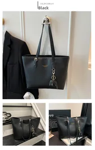 Close-up of black leather tote bag with gold lettering and cute elephant charm detail