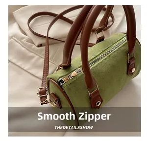 Detail showing the smooth golden zipper and premium green suede on the Boston bag