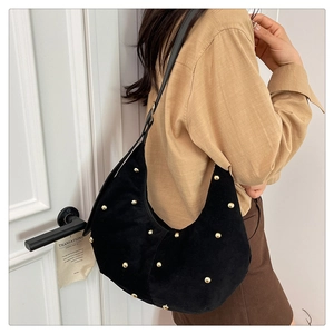 Detailaufnahme der Vintage-Wildleder-Einkaufstasche mit goldenen Nieten am Model