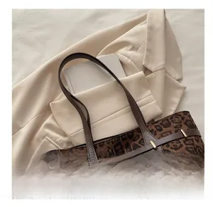 Detail van de luipaardprint tote bag met bruine leren riem en gouden metalen gesp