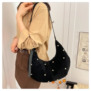 Dettaglio della borsa hobo in camoscio nero con borchie dorate e tracolla in pelle