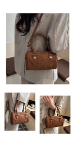 Detail of vintage matte brown cylinder bag with gold hardware and embossed brand logo