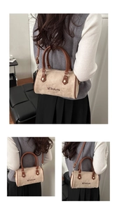 Detail of beige suede Boston bag featuring brown leather handles and M'DoLnu logo lettering