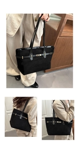 Detail view of black suede tote bag with gold metal buckle and shoulder strap