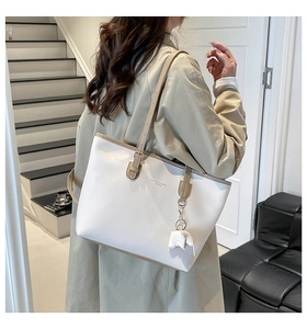 Detail van de crème lederen shopper met bruine bies en schattige dierlijke bedel
