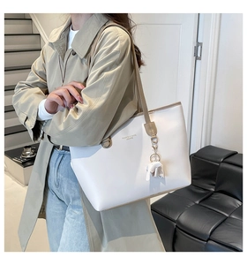 Détail du sac cabas blanc avec anses marron et charmant pendentif éléphant décoratif