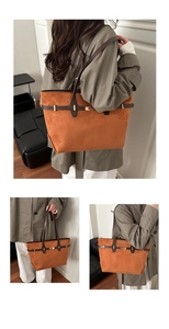 Detail of vintage orange suede tote bag featuring a leather strap and metallic buckle