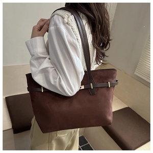 Detailansicht der dunkelbraunen Wildleder-Tote-Bag mit goldener Hardware an der Schulter