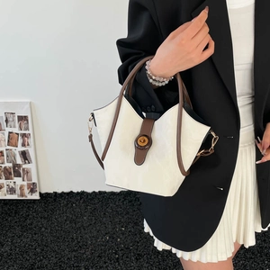 Bolso tipo cubo minimalista en crema y marrón con cierre dorado y textura plisada