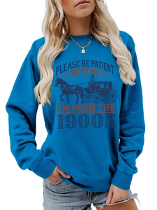Detail of blue sweatshirt with 'Please Be Patient With Me' vintage text and graphic print