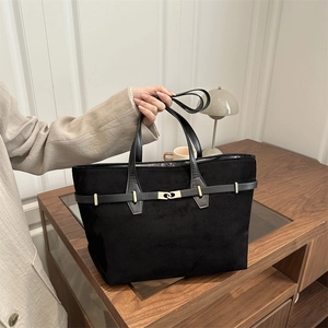 Klassische schwarze Wildleder-Einkaufstasche mit goldenen Details in Wohnambiente