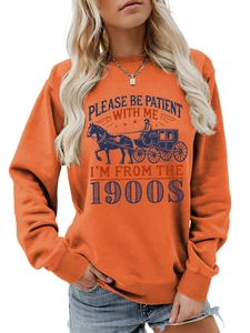 Detail of orange sweatshirt with vintage carriage print and Please Be Patient lettering