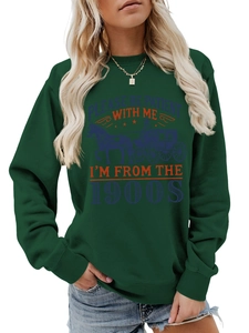 Detail of the vintage slogan print on a dark green crewneck sweatshirt for women