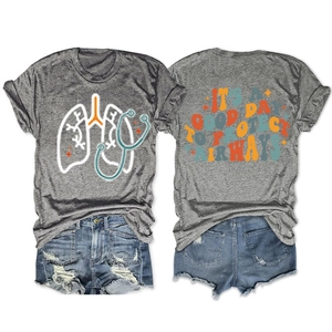 Vista piatta di una t-shirt grigia con grafica medica e pantaloncini di jeans sfrangiati