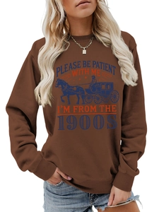 Close-up of vintage horse carriage print and lettering on brown cotton sweatshirt