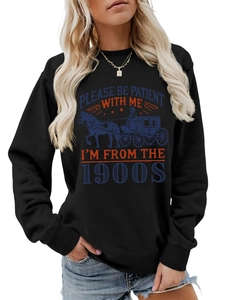 Detail of a black crewneck sweatshirt featuring a vintage carriage and slogan print