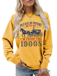 Detail of vintage carriage print and text on mustard yellow crewneck sweatshirt