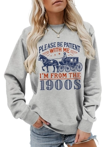 Detail of vintage carriage print and Please Be Patient text on grey cotton sweatshirt