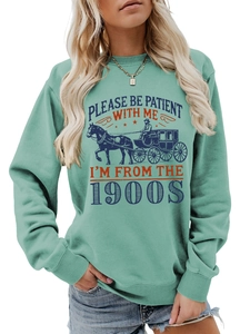 Detail of mint green sweatshirt featuring vintage carriage print and retro 1900s typography