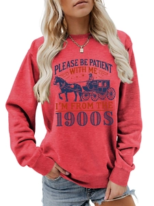 Detail of red crewneck sweatshirt featuring a vintage blue carriage and slogan print