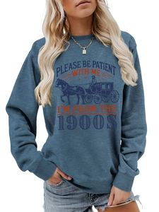 Detail of blue crewneck sweatshirt featuring retro horse carriage print and humorous quote