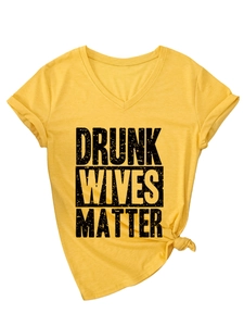 Detail of V-neck yellow cotton T-shirt featuring knotted hem and black letter print
