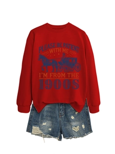 Detailed view of red crewneck sweatshirt with vintage print and distressed denim shorts