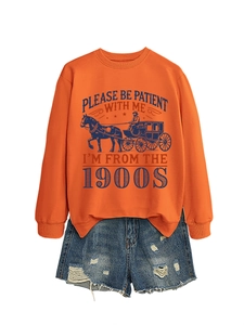 Detail of orange sweatshirt with vintage lettering and distressed denim shorts