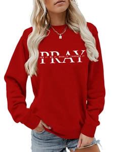 Close-up of red crewneck sweatshirt featuring white Pray letter print on high-quality knit fabric