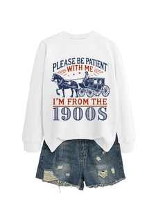 Detail of white sweatshirt with vintage carriage print and distressed denim shorts