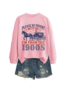 Flat lay of pink sweatshirt with vintage carriage print and distressed denim shorts