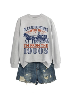 Flat lay of gray sweatshirt with vintage carriage print and distressed denim shorts