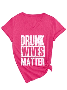 Macro detail of V-neck fuchsia T-shirt with white text and decorative bottom knot