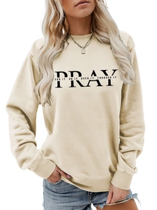 Close-up of cream crewneck sweatshirt featuring PRAY artistic black letter printing
