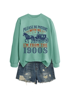 Detail of mint green sweatshirt with retro carriage print and ripped denim shorts set