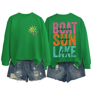 Detail view of green sweatshirt with sun pattern and blue distressed denim shorts set