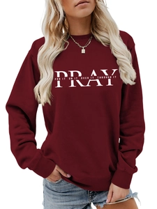 Detail of burgundy crewneck sweatshirt with PRAY print and white lettering text
