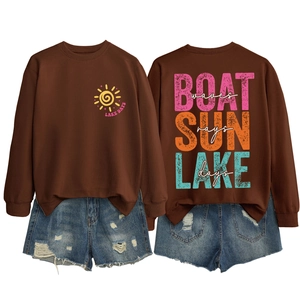 Flat lay view of brown sweatshirt back with colorful Boat Waves Sun Rays text print