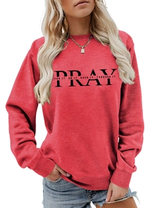 Detail of red crewneck sweatshirt featuring PRAY print and ribbed cuffs for women