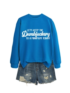 Flat lay of blue sweatshirt with quote and distressed denim shorts for casual style