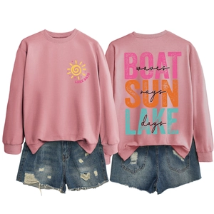 Detail of pink Lake Days sweatshirt and distressed denim shorts with sun and boat prints