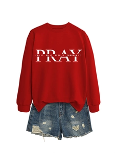 Detailed flat lay of red sweatshirt with Pray For It text and ripped denim shorts