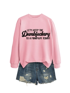 Pink crewneck sweatshirt featuring black slogan and distressed denim shorts for a casual look