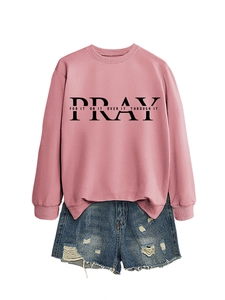Detail of pink crewneck sweatshirt with Pray text print and denim shorts on white background