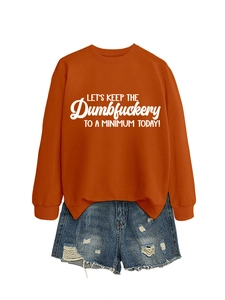 Flat lay of an orange long-sleeve slogan sweatshirt with blue distressed denim shorts