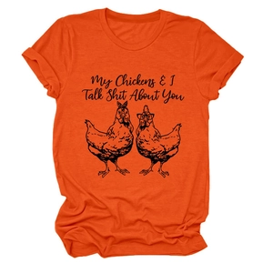 Close-up of orange cotton t-shirt with chicken print and witty English typography