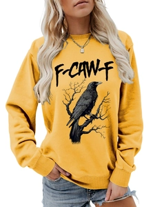 Dettaglio della stampa con corvo nero e grafica F-CAW-F sulla felpa color giallo senape