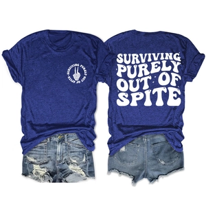 Detalle de la camiseta azul real con texto vintage blanco SURVIVING PURELY OUT OF SPITE