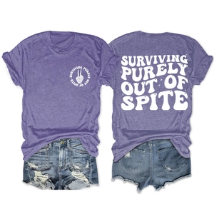 Camiseta morada en plano con el estampado 'Surviving Purely Out Of Spite' detrás